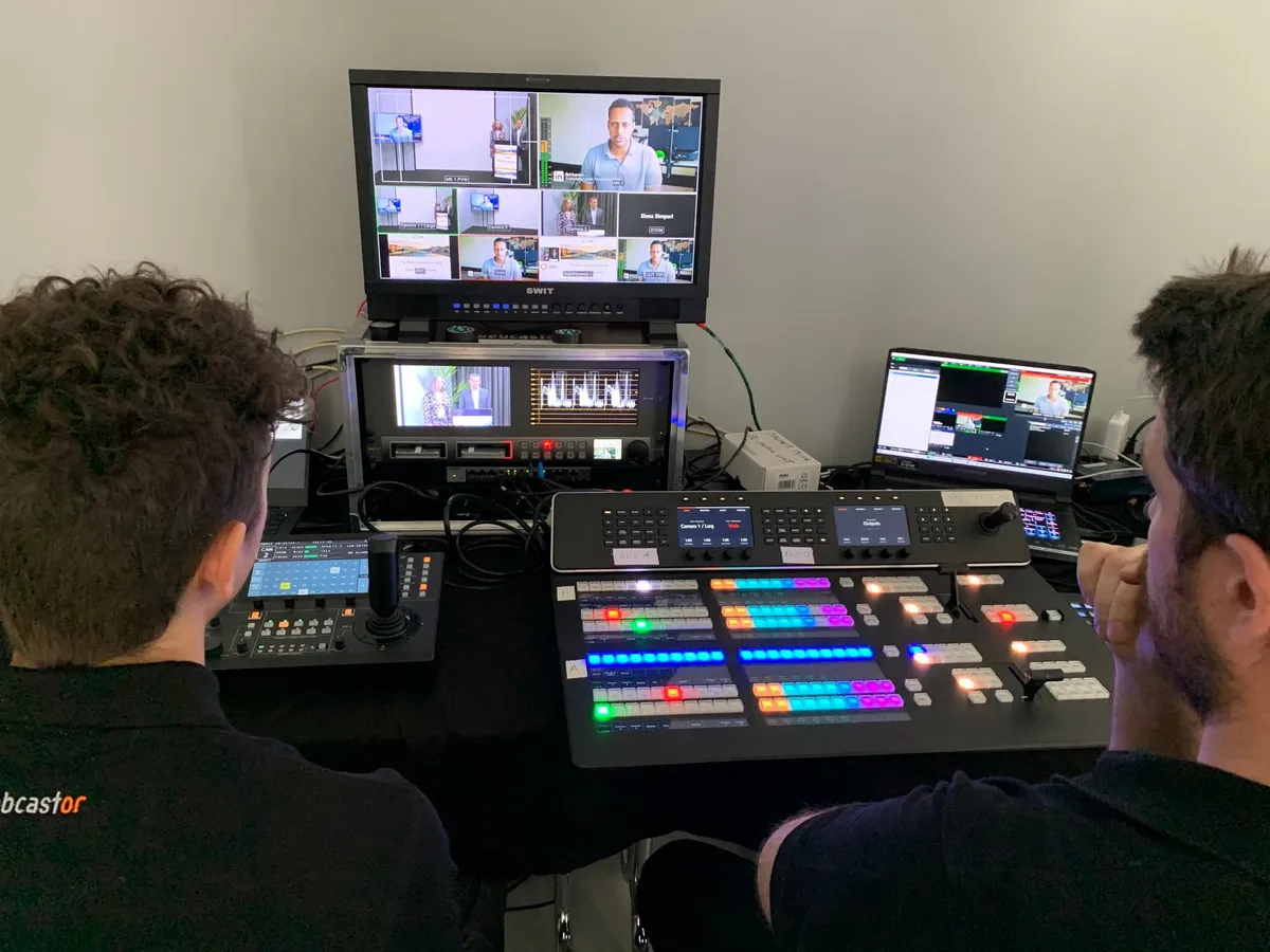 Techniciens Webcastor en régie avec mélangeur vidéo professionnel lors d'une production de communication vidéo d'entreprise
